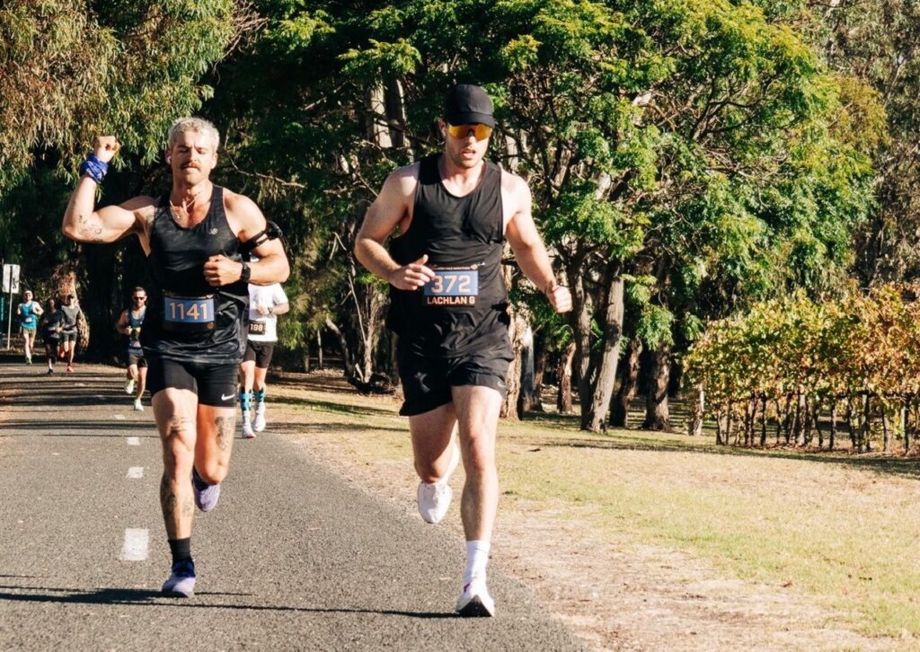 Lachlan Gillies running alongside another participant during a marathon