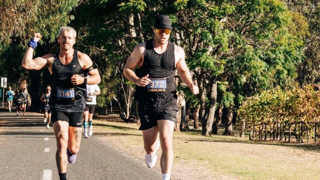 Lachlan Gillies running alongside another participant during a marathon