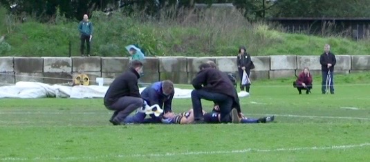 Physiotherapist Lachlan Gillies assisting with pitch-side management of a head and neck injury during a rugby match.